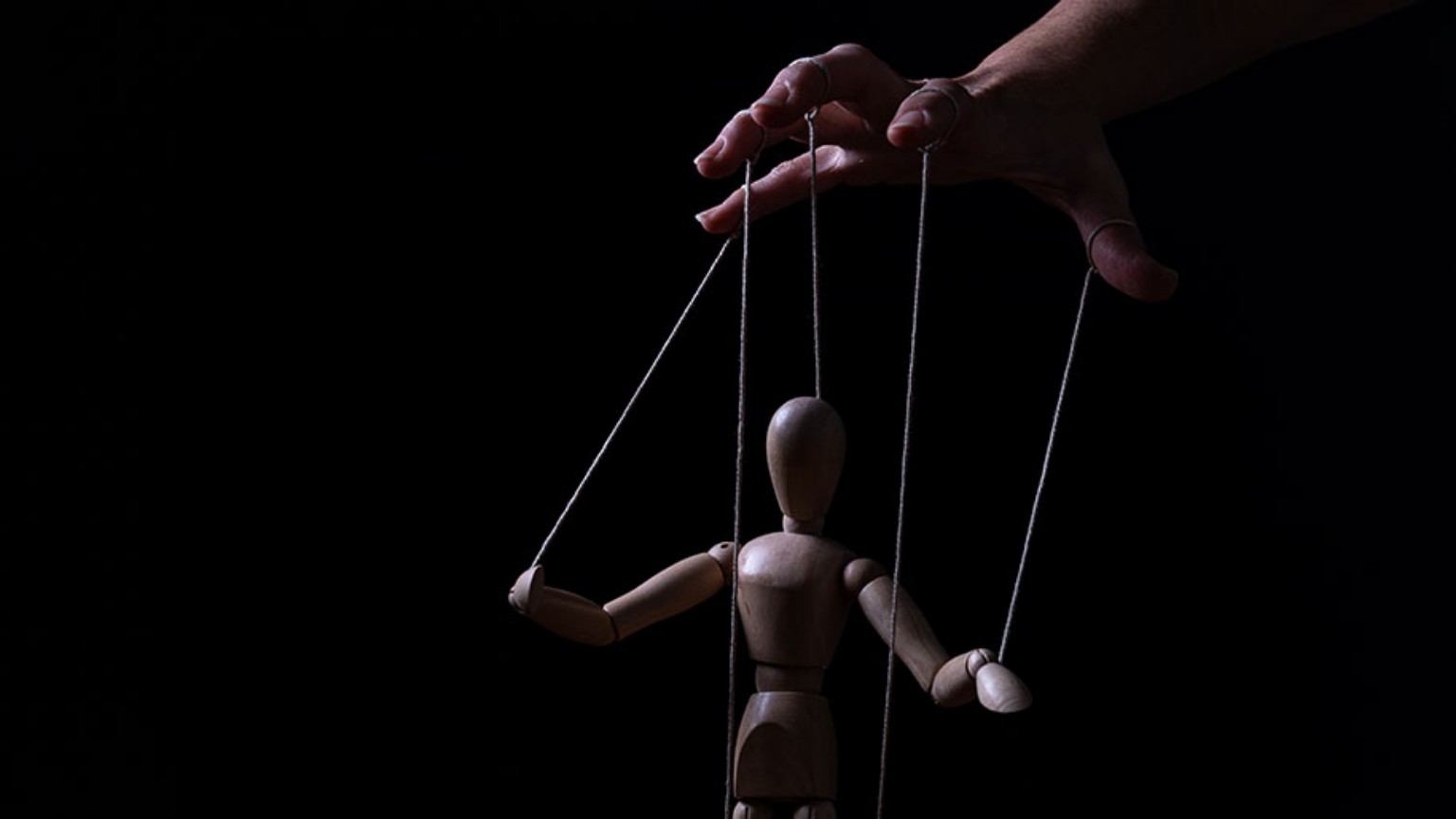 Une marionnette en bois suspendue à des fils