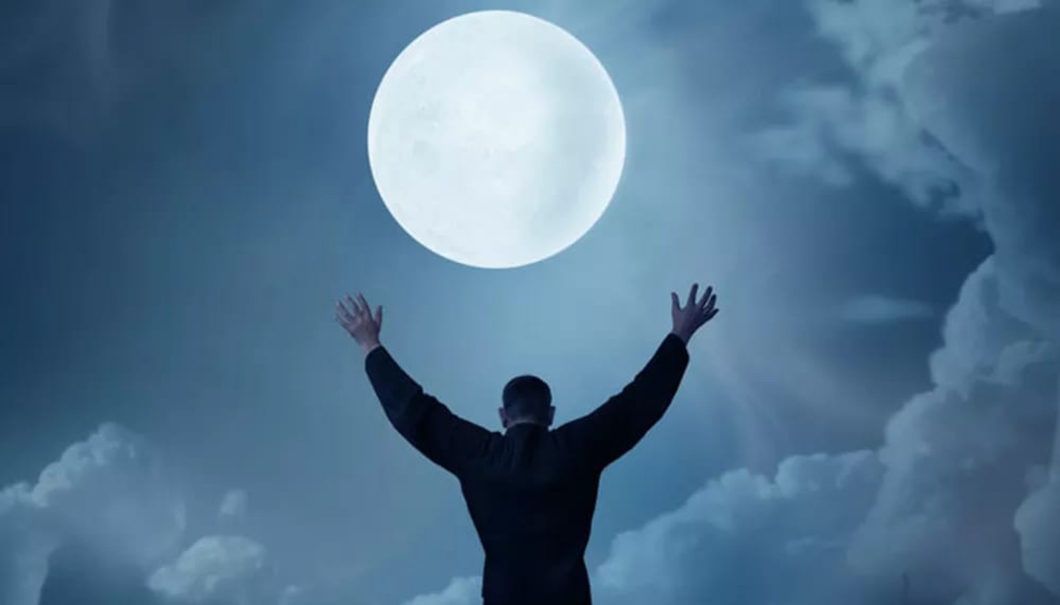 Une silhouette lève les bras sous une grande lune